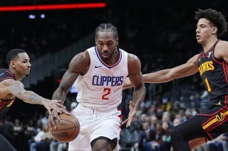 Kawhi Leonard (2) échappe à Dejounte Murray (à gauche) et à Jalen Johnson. KEYSTONE/AP/John Bazemore